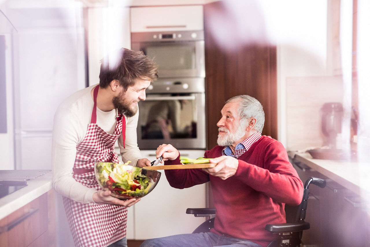 Man and father in wheelchair in kitchen